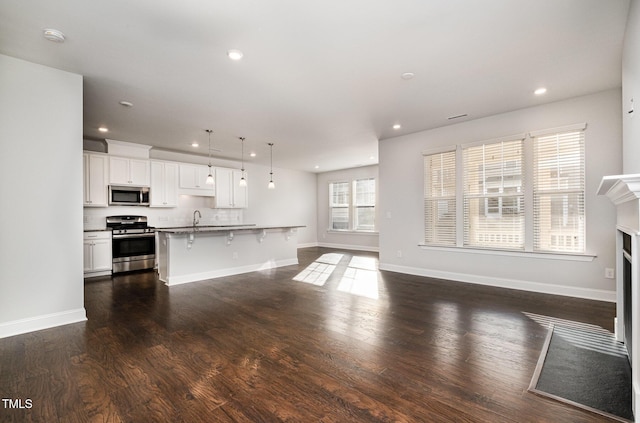 unfurnished living room with sink and dark wood-type flooring