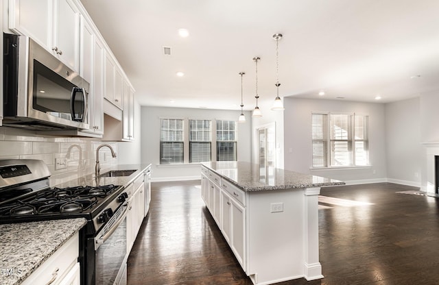 kitchen with stainless steel appliances, a center island, and white cabinets