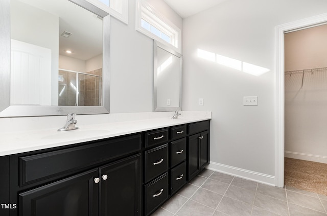 bathroom featuring tile patterned flooring, vanity, and a shower with door