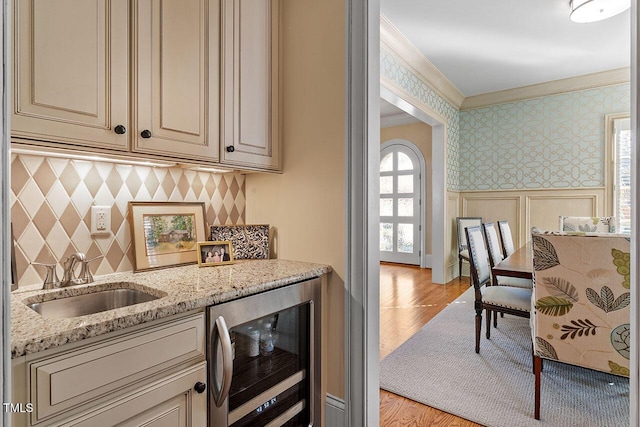 kitchen with sink, beverage cooler, and cream cabinetry