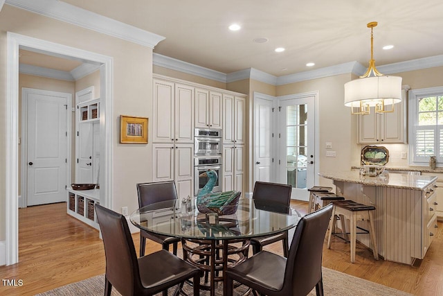 dining space featuring crown molding and light wood-type flooring