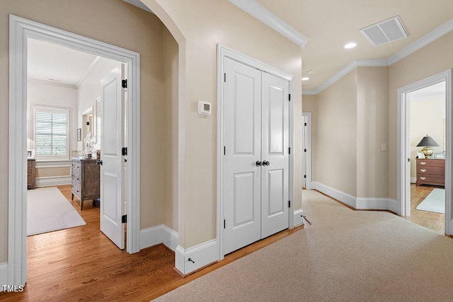 hallway with crown molding and light hardwood / wood-style floors