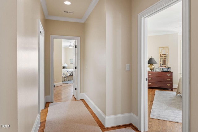 hallway with crown molding and light hardwood / wood-style floors