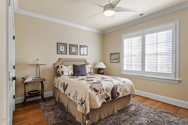 bedroom with hardwood / wood-style flooring, ornamental molding, and ceiling fan