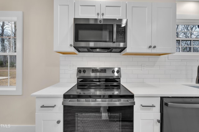 kitchen with appliances with stainless steel finishes, decorative backsplash, and white cabinets