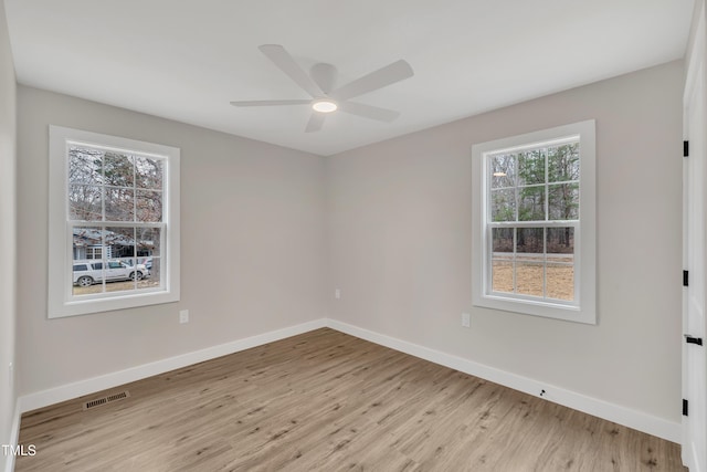 unfurnished room with ceiling fan, light wood-type flooring, and a wealth of natural light