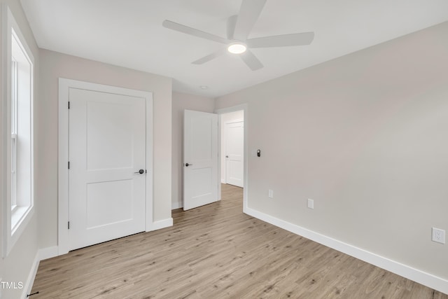 unfurnished bedroom with ceiling fan and light wood-type flooring