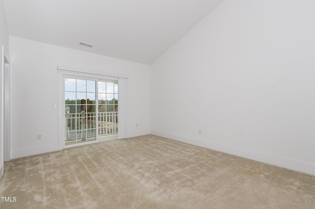 spare room with light colored carpet and vaulted ceiling