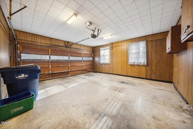 garage with a garage door opener and wooden walls