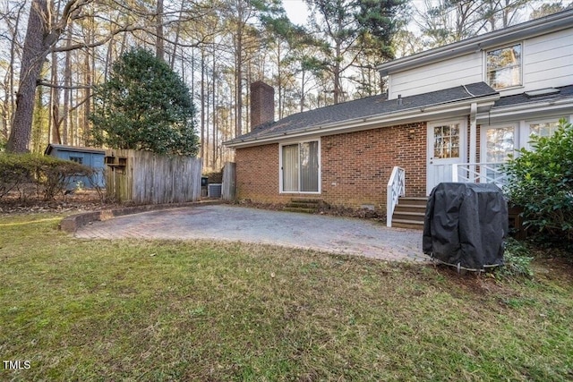 back of property with a lawn and a patio