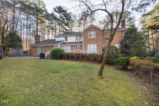 rear view of property with a lawn