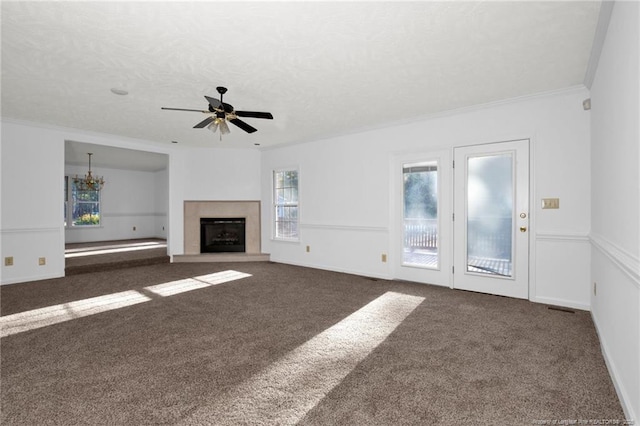 unfurnished living room featuring ornamental molding, ceiling fan with notable chandelier, a textured ceiling, and dark carpet