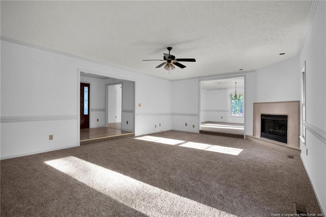 unfurnished living room with ornamental molding, carpet, and ceiling fan