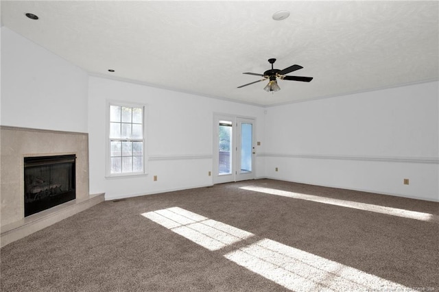 unfurnished living room with carpet flooring, plenty of natural light, a fireplace, and ornamental molding