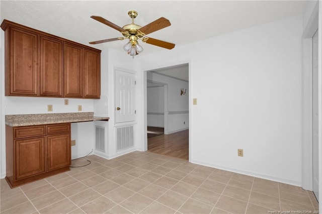 kitchen featuring ceiling fan and built in desk