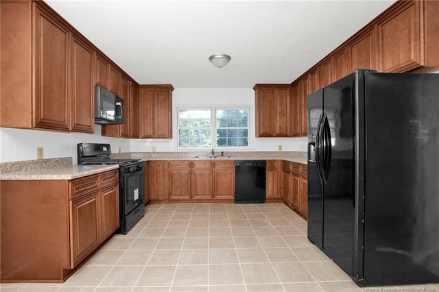 kitchen with sink, light tile patterned floors, and black appliances