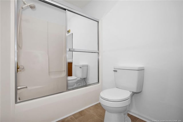 bathroom featuring enclosed tub / shower combo, toilet, and tile patterned flooring