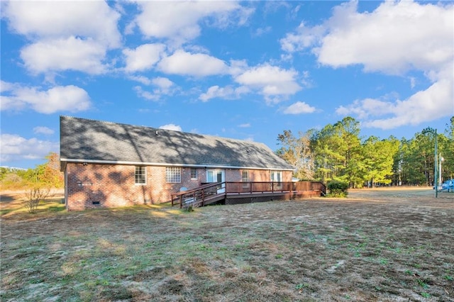 back of property featuring a deck and a lawn