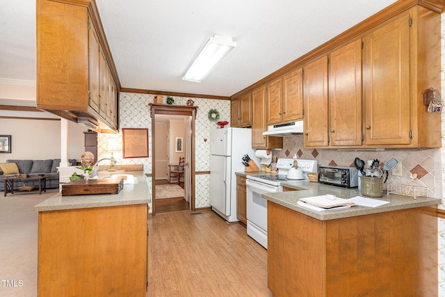 kitchen with sink, light wood-type flooring, ornamental molding, kitchen peninsula, and white appliances