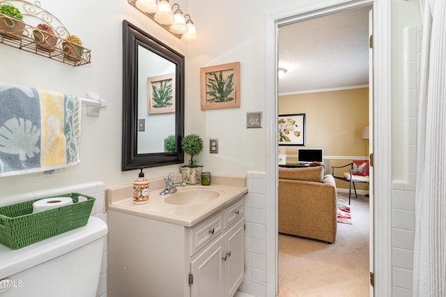 bathroom with crown molding, vanity, a textured ceiling, and toilet