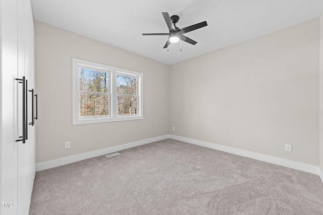 carpeted empty room featuring ceiling fan