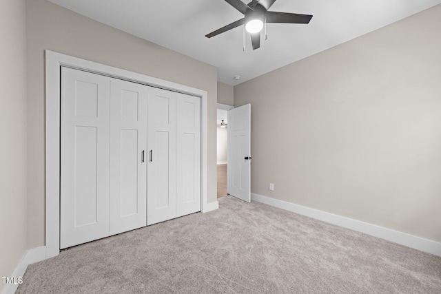 unfurnished bedroom featuring ceiling fan, light colored carpet, and a closet