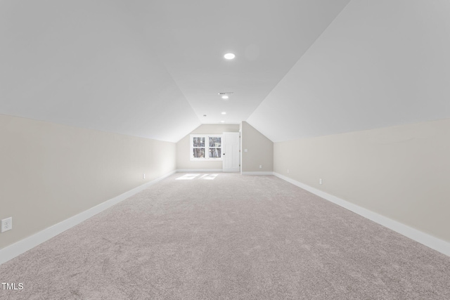 additional living space with vaulted ceiling and carpet flooring