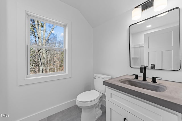 bathroom featuring vanity, lofted ceiling, tile patterned floors, and toilet