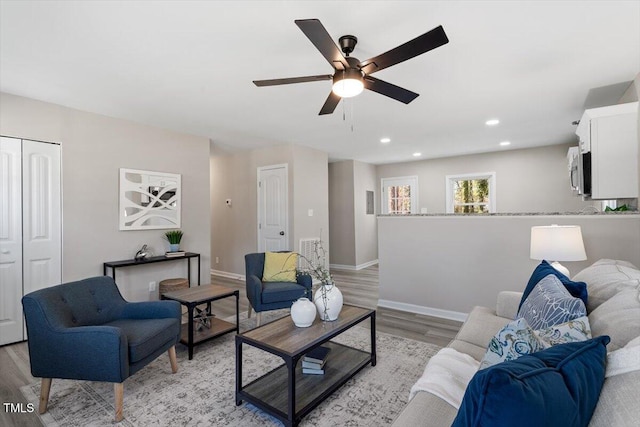 living room with light wood-style flooring, recessed lighting, visible vents, a ceiling fan, and baseboards