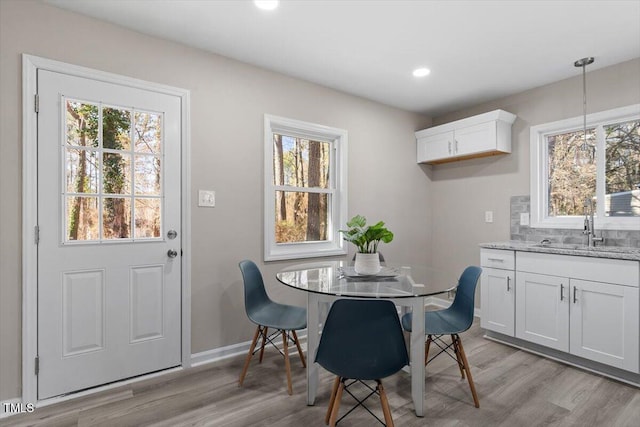 dining room with light wood finished floors, plenty of natural light, recessed lighting, and baseboards