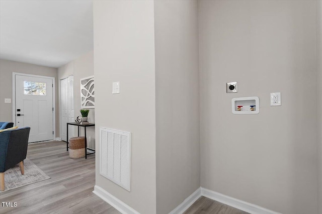 foyer featuring light wood-style floors, visible vents, and baseboards