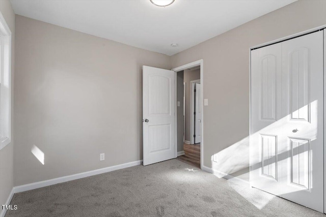 unfurnished bedroom featuring a closet, baseboards, and carpet flooring