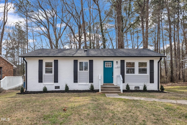 ranch-style house featuring brick siding, crawl space, a front yard, and a shingled roof