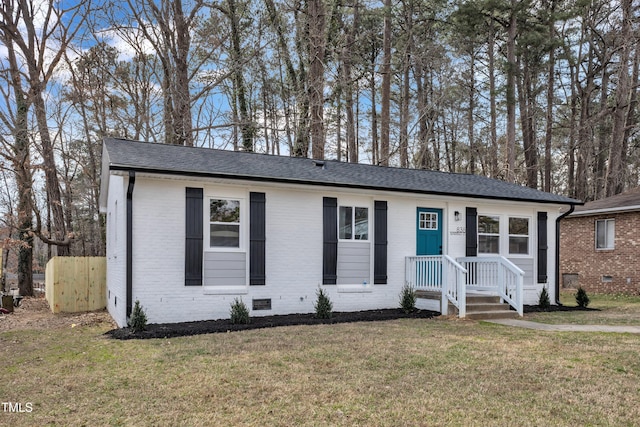 single story home featuring crawl space, roof with shingles, a front yard, and brick siding