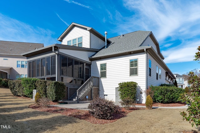 back of property featuring a yard and a sunroom