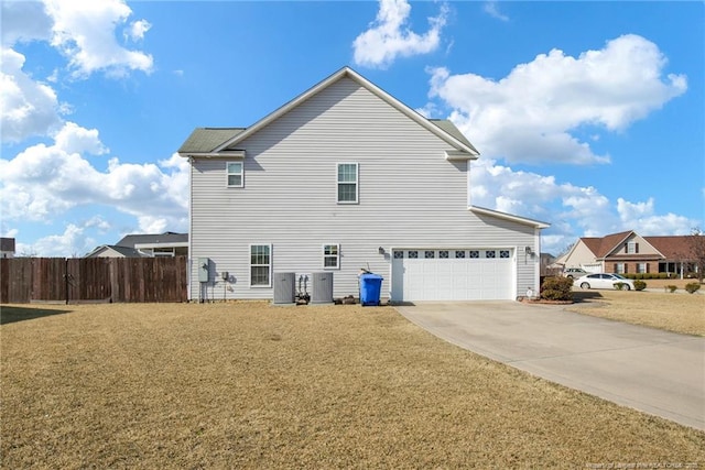 exterior space featuring a garage, a yard, and central AC