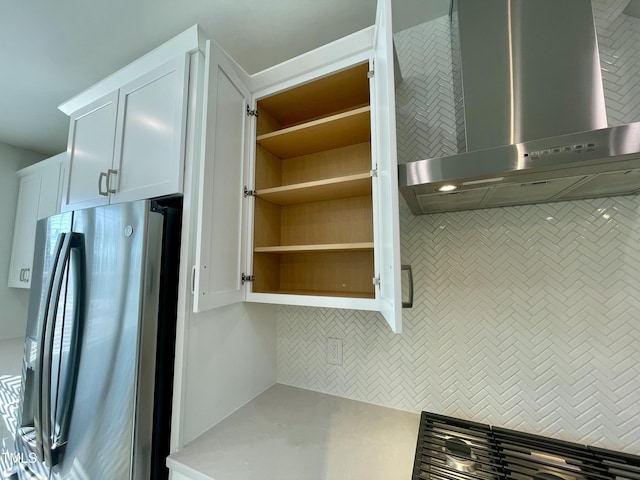 kitchen featuring decorative backsplash, exhaust hood, white cabinets, and stainless steel refrigerator with ice dispenser