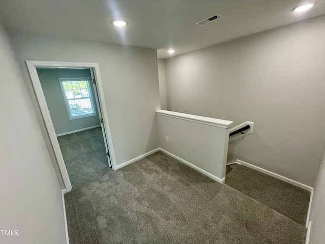 hallway with dark colored carpet