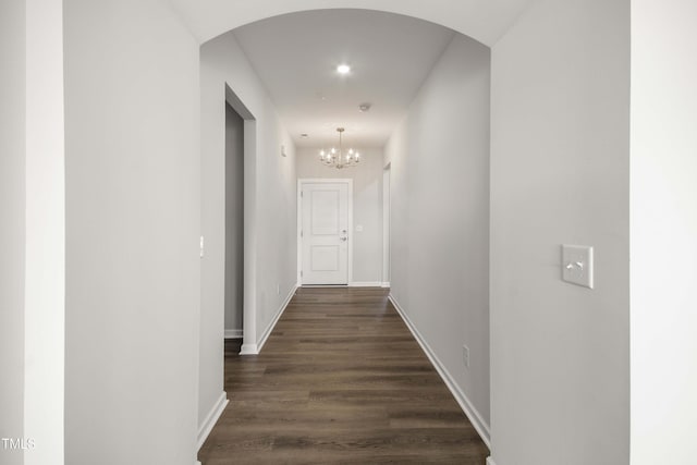 hall featuring dark hardwood / wood-style floors and a chandelier