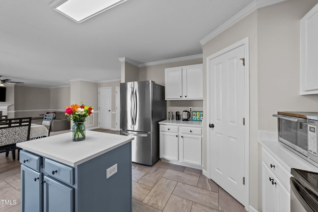 kitchen with white cabinetry, crown molding, a kitchen island, and appliances with stainless steel finishes