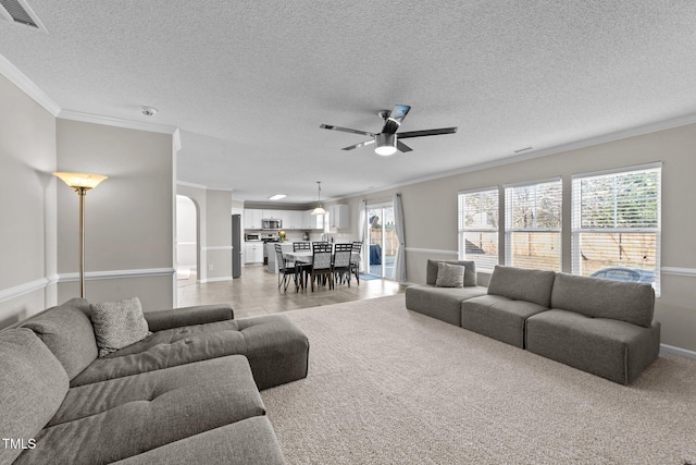 living room with a textured ceiling, ornamental molding, and ceiling fan