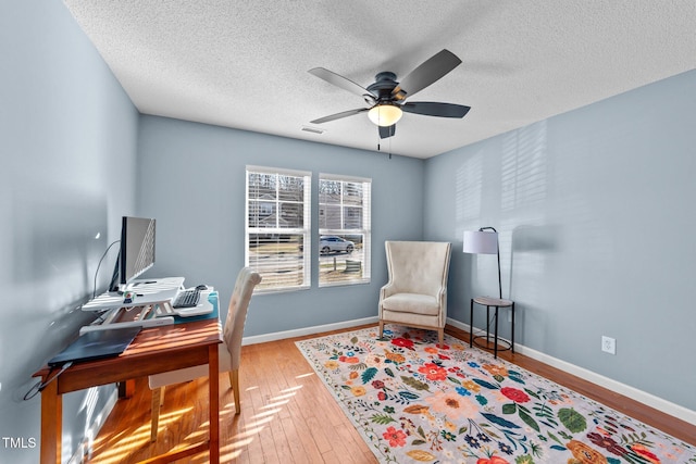 home office with ceiling fan, wood-type flooring, and a textured ceiling