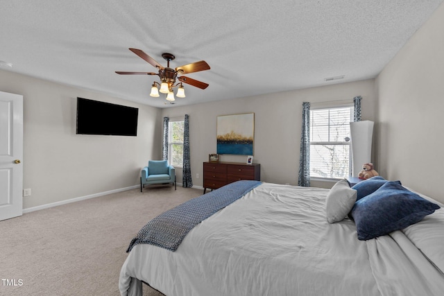 carpeted bedroom with ceiling fan and a textured ceiling