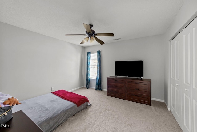 carpeted bedroom with ceiling fan and a closet