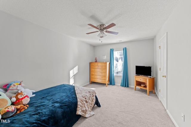 bedroom with ceiling fan, carpet flooring, and a textured ceiling