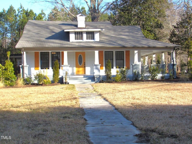 view of front of property featuring covered porch and a front lawn