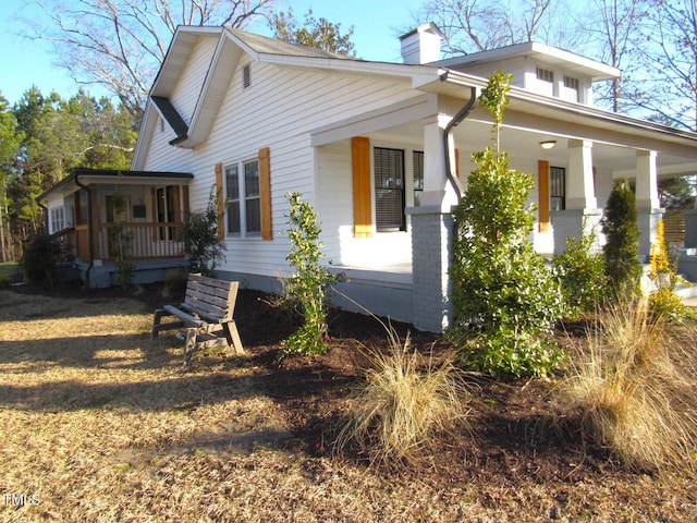 view of side of home with covered porch