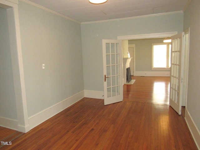 empty room with hardwood / wood-style flooring, ornamental molding, and french doors