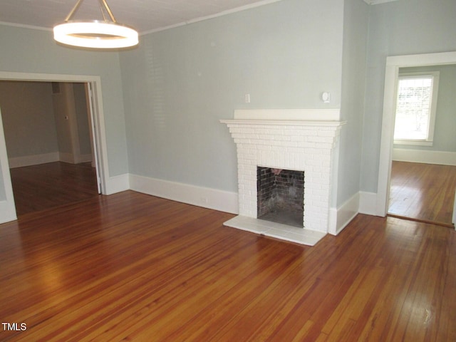 unfurnished living room with ornamental molding, dark hardwood / wood-style floors, and a fireplace