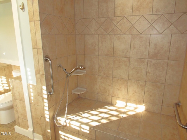 bathroom with tile walls, toilet, and tiled shower